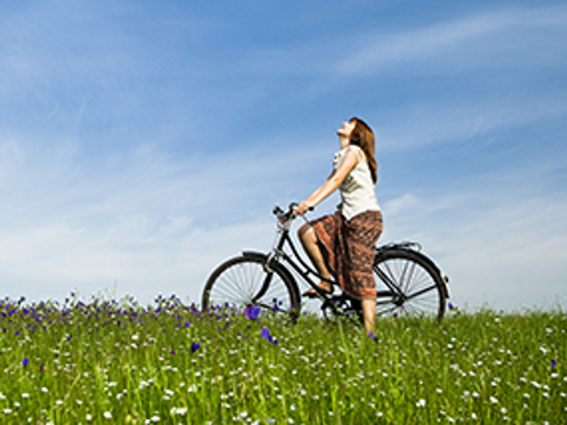 Vrouw op fiets in weiland